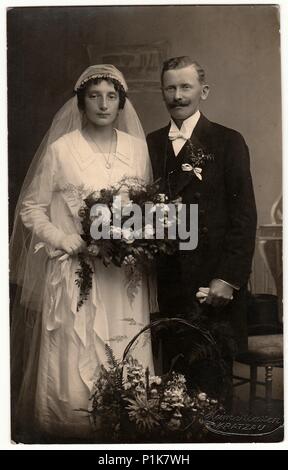 CHRASTAVA (KRATZAU), RÉPUBLIQUE TCHÉCOSLOVAQUE - VERS 1930s : photo d'époque des jeunes mariés. La mariée porte un voile et tient le bouquet de mariage. Portrait de studio antique en noir et blanc. 1930s Banque D'Images