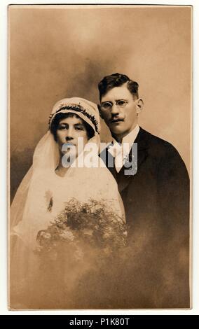 LA RÉPUBLIQUE TCHÉCOSLOVAQUE - VERS 1930s : photo d'époque des jeunes mariés. La mariée porte un voile et tient le bouquet de mariage. Le marié porte un costume noir et un noeud papillon blanc. Portrait de studio antique en noir et blanc. 1930s Banque D'Images