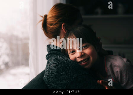 Mother and Daughter sitting on couch serrant les uns les autres Banque D'Images