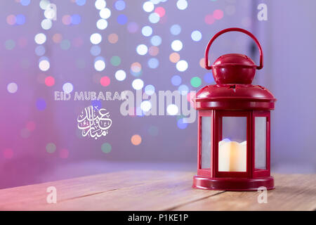 L'Eid al-Fitr Mubarak Greeting typographie avec arrière-plan flou. Sur le fond en bois lanterne arabe Banque D'Images