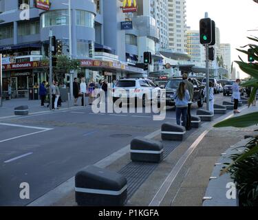 Les piétons de traverser d'attente alors que le trafic de la rue passer au signal vert à Esplanade street, Surfers Paradise, Gold Coast, Australie Banque D'Images