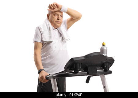 Exhausted senior sur un tapis roulant isolé sur fond blanc Banque D'Images