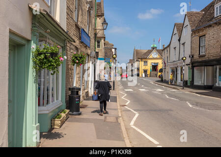 Les gens marchent le long de la rue de l'Église vers la Halle, Tetbury, Gloucestershire, Royaume-Uni. Bâtiments historiques en pierre de Cotswold bordent la rue. Banque D'Images