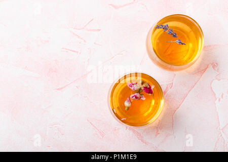 Une tisane faite de boutons de roses séchées et des fleurs de lavande dans deux plaques de verre transparent. Banque D'Images