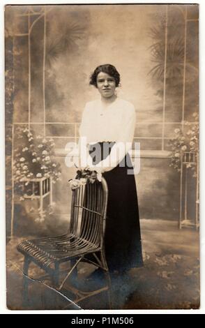 Allemagne - circa 1930 : Vintage photo montre jeune femme pose avec des fleurs dans un studio de photo. Photographie avec effet sépia. Banque D'Images