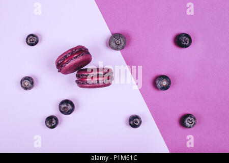 Deux macarons violet sur fond rouge Banque D'Images