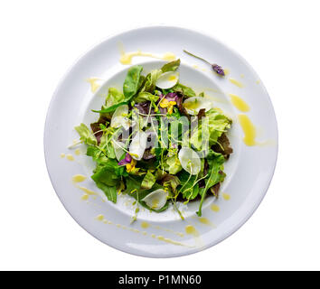 Salade de laitue en bonne santé avec des fleurs comestibles et microgreens sur plaque blanche isoler sur blanc. Vue d'en haut. Banque D'Images