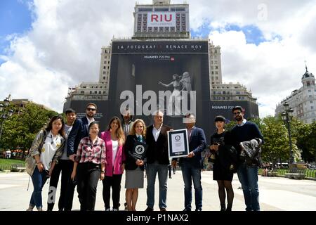 Madrid, Espagne. 12 Juin, 2018. Les gens posent pour des photos avec le record mondial Guinness certificat en face de l'Huawei P20 Pro publicité à l'extérieur d'un bâtiment à Madrid, Espagne, le 12 juin 2018. Huawei a reçu mardi un record mondial Guinness pour le plus important certificat 'échafaudage bannière dans le monde". Credit : Guo Qiuda/Xinhua/Alamy Live News Banque D'Images