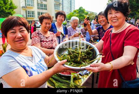 (180613) -- YONGQING, 13 juin 2018 (Xinhua) -- Les résidants montrent Zongzi, une boulette en forme de pyramide fait de riz gluant enveloppé dans des feuilles de roseau ou de bambou, d'accueillir le prochain Festival du bateau-dragon à une communauté dans le comté de Baoshan, Chine du nord, dans la province du Hebei, le 13 juin 2018. (Xinhua/Li Xiaoguo) (zwx) Banque D'Images