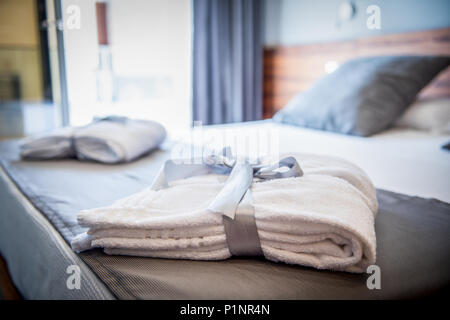 Peignoir sur lit dans chambre d'hôtel Banque D'Images