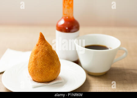 Des bouchées de poulet frit appelé Coxinha au Brésil. Les Brésiliens mangent comme alternative à la restauration rapide ou des parties. Snack, café et sa sauce au poivre. Bar Banque D'Images