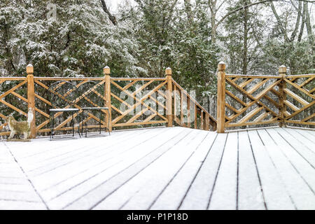 Terrasse en bois vides de la maison avec des décorations, des chaises, statue sur l'escalier en arrière-cour quartier avec plancher de bois couverte de neige pendant un blizzard wh Banque D'Images