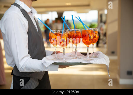 Le serveur sert des cocktails sur un bac. Close-up rouge et orange et menthe orange avec des cocktails au restaurant Banque D'Images