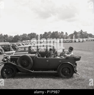 1955, aux courses, tableau historique de trois riches, messieurs habillés en costumes et porter un chapeau, assis à l'arrière d'un touring car à l'extérieur dans le parking d'un hippodrome, England, UK. Banque D'Images