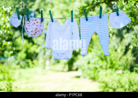 Vêtements de bébé sur corde à linge dans le jardin Banque D'Images