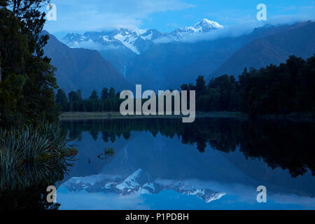 Sommets du Mt Tasman (à gauche) et l'Aoraki / Mt Cook (droite) reflète dans Lake Matheson, Westland National Park, West Coast, South Island, New Zealand Banque D'Images