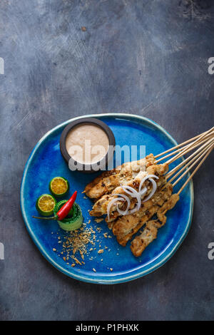 Brochettes de poulet indonésien sate, sauce aux arachides et de la salade, vue de dessus, copyspace. Banque D'Images