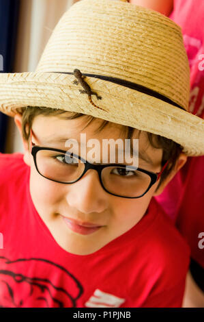 Garçon avec bébé lézard sur son chapeau de paille tropical ; Varadero, Cuba Banque D'Images