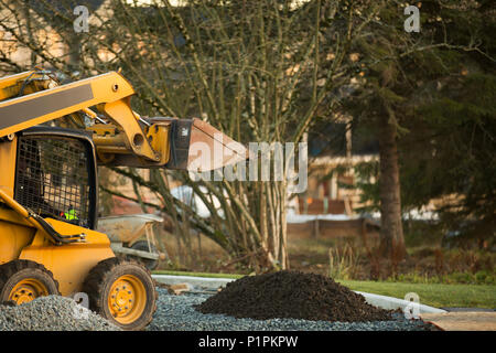 Petit chargeur avant déménagement et plaçant de gravier dans un parc d'une nouvelle construction ; Langley, Colombie-Britannique, Canada Banque D'Images