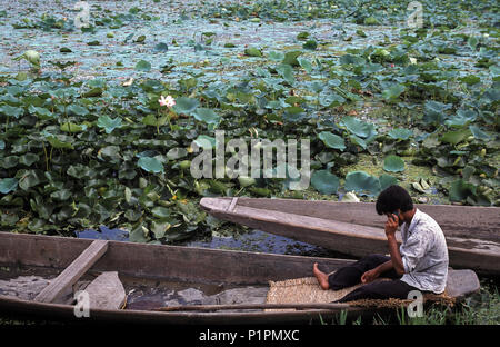 Srinagar, Inde, l'homme assis dans un bateau en bois sur le lac Dal Banque D'Images