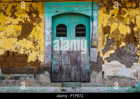 Usé et patiné façade d'un bâtiment avec l'écaillage de la peinture et des doubles portes ; Nicaragua Banque D'Images