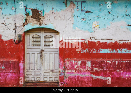 Usé et patiné façade d'un bâtiment avec l'écaillage de la peinture et des doubles portes ; Nicaragua Banque D'Images