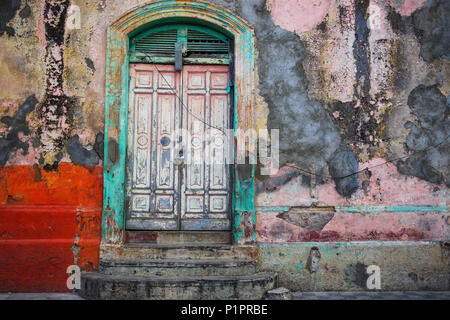 Usé et patiné façade d'un bâtiment avec l'écaillage de la peinture et des doubles portes ; Nicaragua Banque D'Images