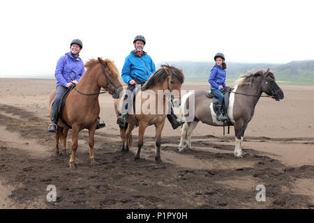 Family riding chevaux Islandais sur une plage de sable, Breidavik, Péninsule de Snæfellsnes, à l'ouest de l'Islande Banque D'Images