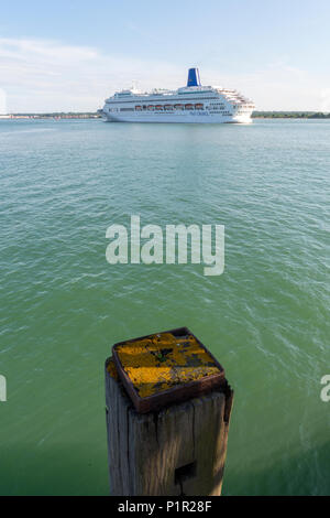 Le p et o cruise liner oriana de quitter le port de Southampton sur une croisière dans les eaux plus chaudes avec un vieux post en bois en premier plan pour donner de la perspective Banque D'Images