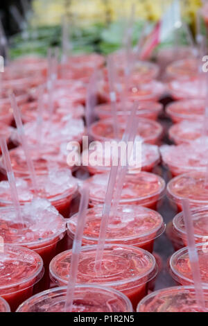 Une grande quantité de boissons de jus de fruits ou smoothies sont alignées en rangées pour la vente à un décrochage boisson de fruits frais sur Borough Market à Londres. Banque D'Images