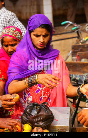 Femme de la région d'acheter des pommes au marché de rue à Fatehpur Sikri, Uttar Pradesh, Inde. La ville a été fondée en 1569 par l'empereur moghol Akbar, et Banque D'Images