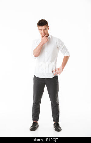 Portrait d'un jeune homme pensif looking at camera isolated over white background Banque D'Images