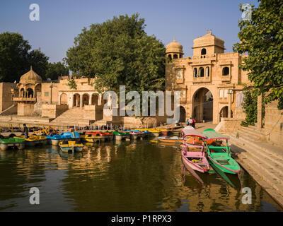 L'amarrage des bateaux colorés le long de la rive du lac Gadsisar, Jaisalmer, Rajasthan, India Banque D'Images