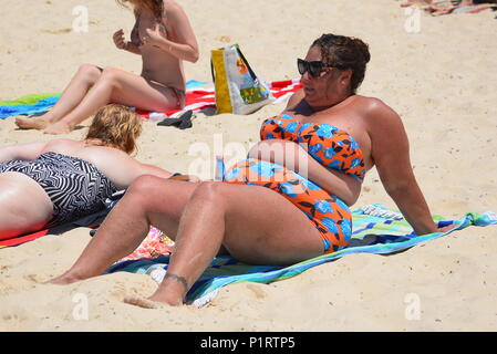 Un excès de poids, de taille plus femme appréciant le soleil sur plage Banque D'Images