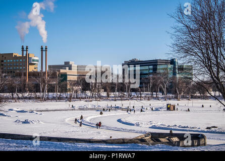 Les gens marcher et patiner le long de la rivière Rouge à Winnipeg, sentier mutuelle artistique où relais chauffés sont à l'écran ; Winnipeg, Manitoba, Canada Banque D'Images