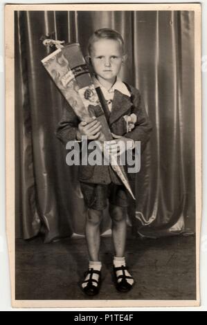 Allemagne - Vers les années 1940 : Vintage photo montre élève garçon avec chultute «» ou cône de l'école, des bonbons pour la première journée à l'école. Studio photo avec teinte sépia. Banque D'Images