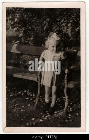 La République tchécoslovaque - septembre 8, 1940 : Vintage photo montre une petite fille entre des bancs de parc. Retro noir et blanc de la photographie. Banque D'Images