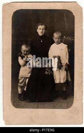 Allemagne - circa 1930 : Vintage photo montre femme et ses enfants dans un studio de photographie. Garçon porte un costume de marin et robe blanche. Retro noir et blanc photographie studio avec effet sépia. Banque D'Images