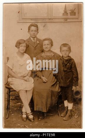 La République tchécoslovaque - VERS 1920 : Vintage photo montre motther et ses enfants posent à l'extérieur. Retro noir et blanc photographie avec effet sépia. Banque D'Images