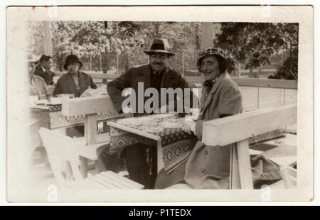 LUHACOVICE, la République tchécoslovaque - circa 1930 : Vintage photo montre la femme et l'homme dans le jardin reataurant. Retro noir et blanc de la photographie. Banque D'Images