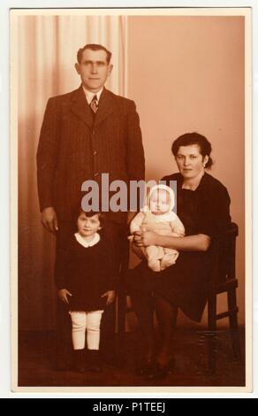 RICANY, la République tchécoslovaque - 1930 : Vintage photo montre la famille dans le studio de photographie. Retro noir et blanc photographie avec effet sépia. Banque D'Images