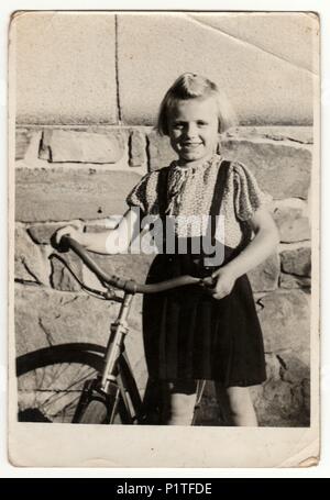 La République tchécoslovaque - circa 1950 : Vintage photo montre une petite fille avec location. Retro noir et blanc de la photographie. Banque D'Images