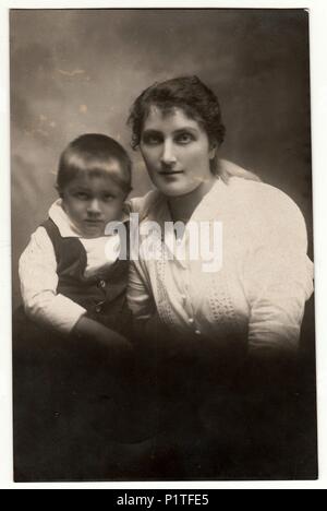 La République tchécoslovaque - VERS 1920 : Vintage photo montre un petit garçon avec sa mère. Retro noir et blanc photographie de studio. Banque D'Images