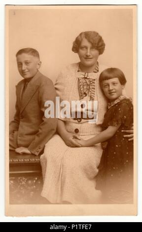 La République tchécoslovaque - VERS 1920 : Vintage photo montre la famille - mère, fils et fille. Retro noir et blanc photographie studio avec effet sépia. Banque D'Images