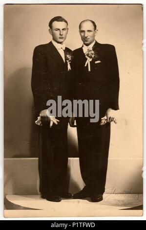 ZLIN, la République tchécoslovaque - VERS 1920 : Vintage photo montre deux hommes (le marié et son meilleur homme) posent en studio de photographie. Retro noir et blanc de la photographie. Banque D'Images