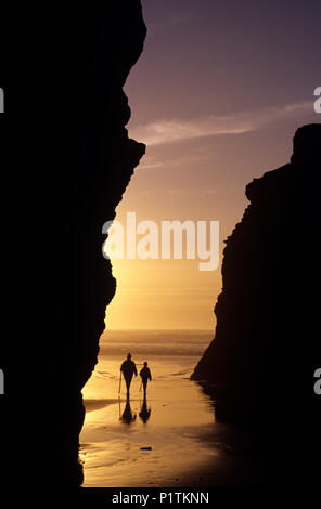 Cape Sebastian le long de la côte sud de l'Oregon, le long de la route 101 avec le coucher du soleil spectaculaire avec une jeune fille mère randonnées avec bâton de marche à marée basse. Banque D'Images