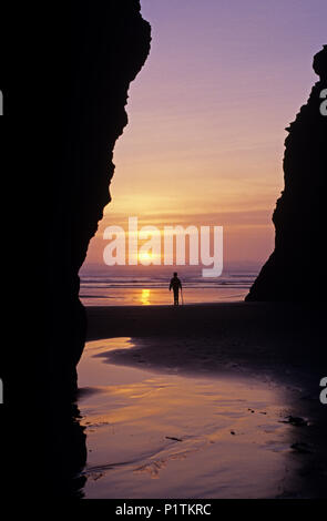 Cape Sebastian le long de la côte sud de l'Oregon, le long de la route 101 avec le coucher du soleil spectaculaire avec jeune fille randonnées avec bâton de marche à marée basse. Banque D'Images