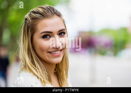 Portrait d'une belle jeune femme sur un campus universitaire avec l'arrière-plan éclaté ; Edmonton, Alberta, Canada Banque D'Images