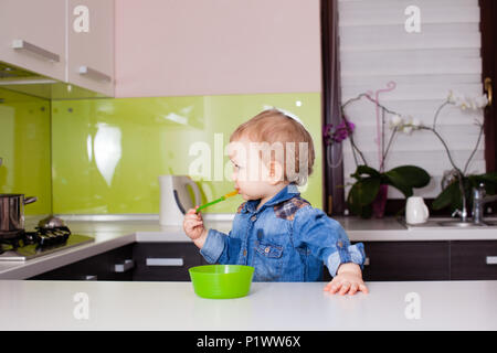 Lovely boy veut essayer la soupe de la mère Banque D'Images