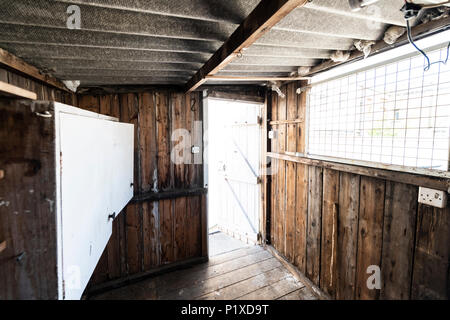 L'intérieur d'un vieux hangar abandonné avec des workbench, placards, étagères, toit de l'amiante et le dangereux. Banque D'Images